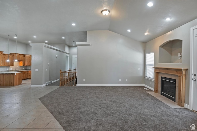 3423 W Mount Cortina Way, Riverton, UT 84065 - unfurnished living room featuring vaulted ceiling, a tiled fireplace, light tile patterned floors, recessed lighting, and a sink