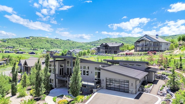 6339 E Quail Ln, Huntsville, UT 84317 - view of front of house featuring stone siding, a mountain view, a residential view, a garage, and asphalt driveway