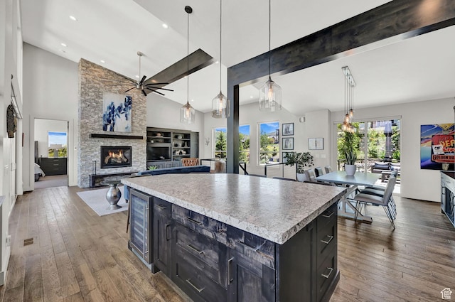 6339 E Quail Ln, Huntsville, UT 84317 - kitchen featuring a fireplace, ceiling fan, beverage cooler, dark cabinetry, and high vaulted ceiling