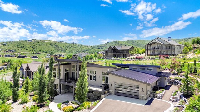 6339 E Quail Ln, Huntsville, UT 84317 - view of front of house with a mountain view, a residential view, stone siding, an attached garage, and driveway