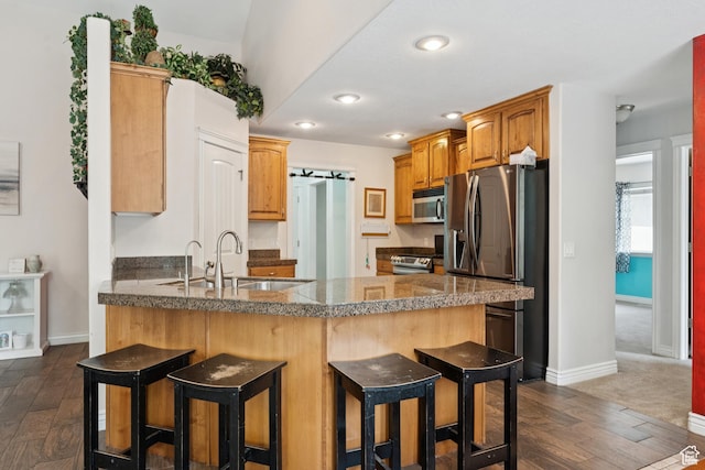 473 W 175 N, Morgan, UT 84050 - kitchen with appliances with stainless steel finishes, a peninsula, a sink, a breakfast bar, and baseboards