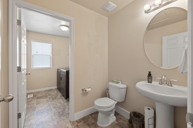 6165 W Haven Ridge Way S, West Valley City, UT 84128 - bathroom with toilet, baseboards, and independent washer and dryer