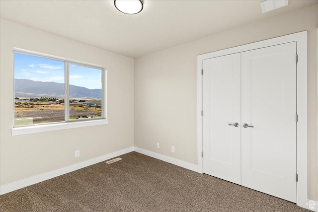 178 S Liberty St Unit 206, Grantsville, UT 84029 - unfurnished bedroom featuring dark colored carpet, baseboards, a mountain view, and a closet