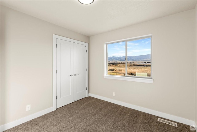 178 S Liberty St Unit 206, Grantsville, UT 84029 - unfurnished bedroom featuring dark carpet, baseboards, a mountain view, and a closet