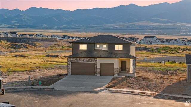178 S Liberty St Unit 206, Grantsville, UT 84029 - view of front of property with stone siding, an attached garage, a mountain view, and concrete driveway