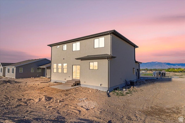 178 S Liberty St Unit 206, Grantsville, UT 84029 - back of house at dusk with cooling unit, stucco siding, and a mountain view
