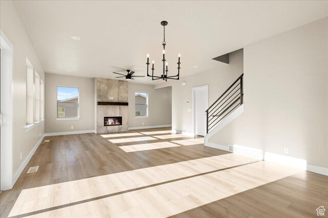 178 S Liberty St Unit 206, Grantsville, UT 84029 - unfurnished living room featuring a chandelier, light wood finished floors, baseboards, stairway, and a fireplace