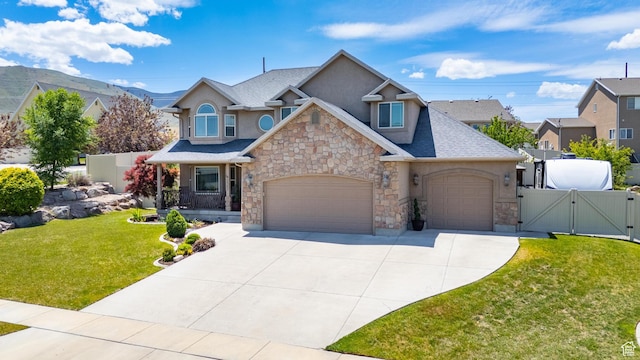 2367 S Wesson Dr, Saratoga Springs, UT 84045 - view of front facade featuring a gate, stone siding, stucco siding, and driveway