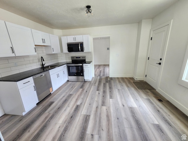 930 E 22nd St, Ogden, UT 84401 - kitchen with stainless steel appliances, a sink, dark countertops, and white cabinets