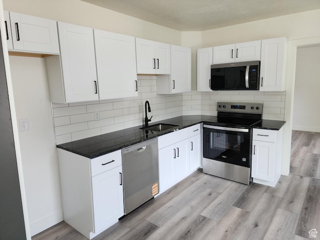 930 E 22nd St, Ogden, UT 84401 - kitchen featuring stainless steel appliances, a sink, white cabinetry, light wood-style floors, and backsplash