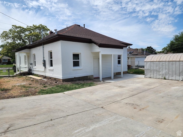 930 E 22nd St, Ogden, UT 84401 - back of house featuring a shingled roof, brick siding, and an outbuilding