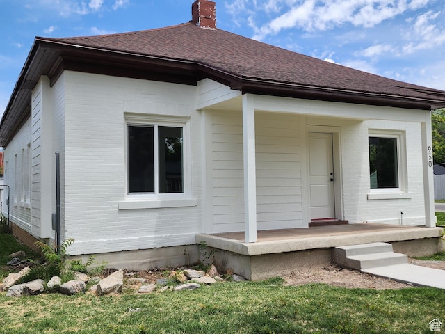 930 E 22nd St, Ogden, UT 84401 - view of front of home featuring a chimney, brick siding, and a shingled roof