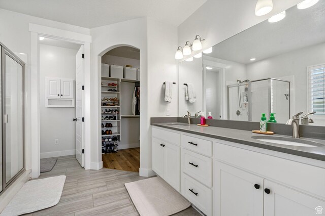722 N Meridian Dr, Saratoga Springs, UT 84045 - bathroom featuring a shower stall, double vanity, a walk in closet, and baseboards