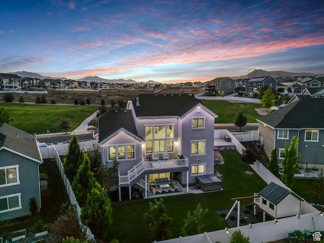 722 N Meridian Dr, Saratoga Springs, UT 84045 - back of house at dusk with a residential view, a wooden deck, and stairs