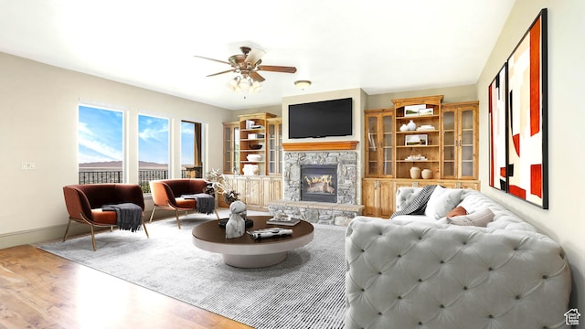 1596 E Millbrook Way S, Bountiful, UT 84010 - living area with a ceiling fan, wood finished floors, a stone fireplace, and baseboards