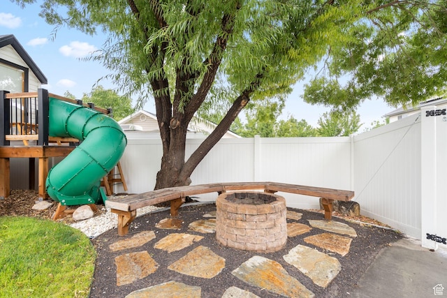 3355 E Golden Eagle Rd, Eagle Mountain, UT 84005 - fenced backyard with a fire pit, a playground, and a patio area
