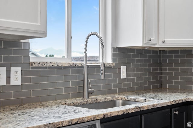 3355 E Golden Eagle Rd, Eagle Mountain, UT 84005 - kitchen view of a sink, white cabinetry, decorative backsplash, and light stone countertops