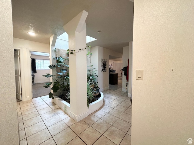344 E Vermillion Ave, St George, UT 84790 - corridor with a textured wall, light tile patterned floors, baseboards, and a skylight
