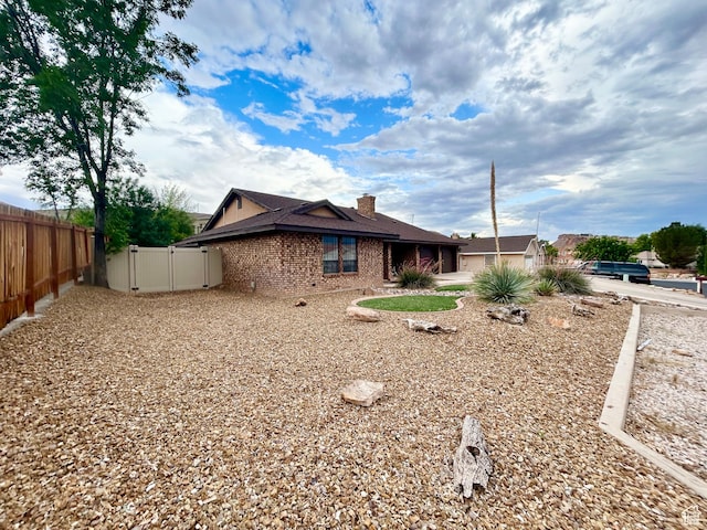 344 E Vermillion Ave, St George, UT 84790 - rear view of house with brick siding, a gate, a chimney, and an attached garage