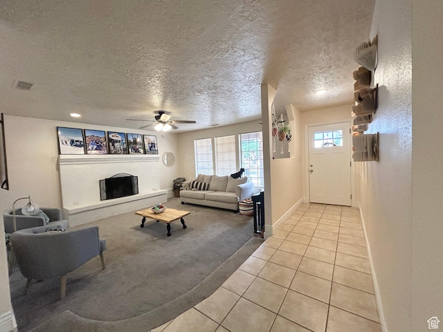 344 E Vermillion Ave, St George, UT 84790 - living area featuring light tile patterned floors, plenty of natural light, light carpet, a textured ceiling, and a fireplace with raised hearth