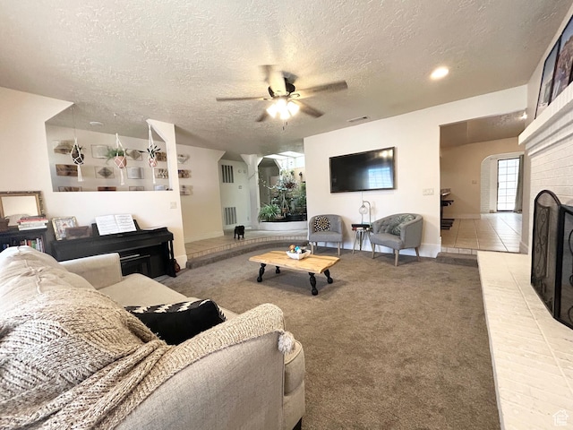 344 E Vermillion Ave, St George, UT 84790 - living room featuring a textured ceiling, ceiling fan, baseboards, light colored carpet, and a brick fireplace