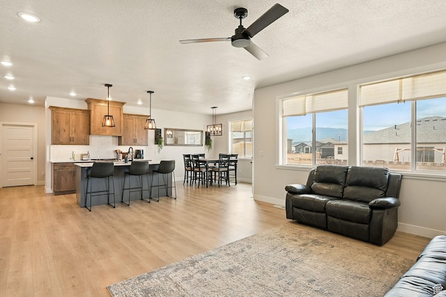 4657 W 275 N, Cedar City, UT 84720 - living room featuring ceiling fan, light wood-style flooring, recessed lighting, baseboards, and a textured ceiling