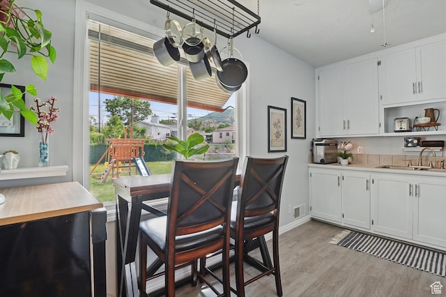 8757 W Helen Dr, Magna, UT 84044 - dining room featuring light wood finished floors, a chandelier, and baseboards