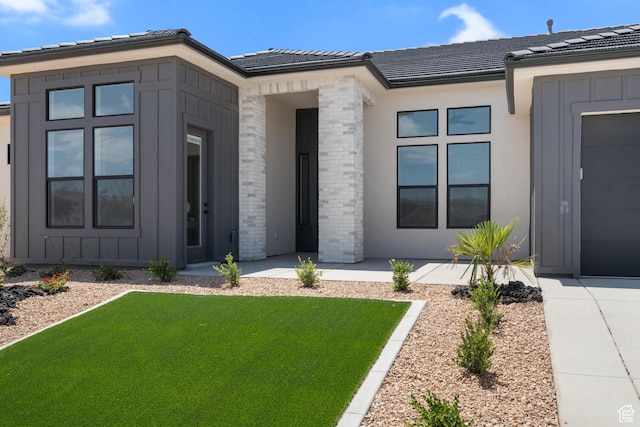 824 S 1690 W, Hurricane, UT 84737 - doorway to property with a lawn, board and batten siding, a garage, and a tile roof