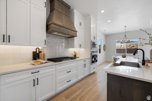 824 S 1690 W, Hurricane, UT 84737 - kitchen featuring premium range hood, appliances with stainless steel finishes, light wood finished floors, white cabinets, and recessed lighting