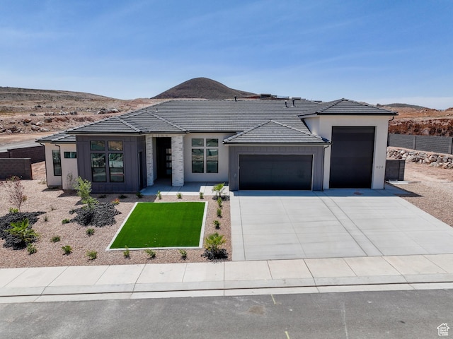 824 S 1690 W, Hurricane, UT 84737 - prairie-style home featuring a garage, board and batten siding, driveway, a tile roof, and a mountain view