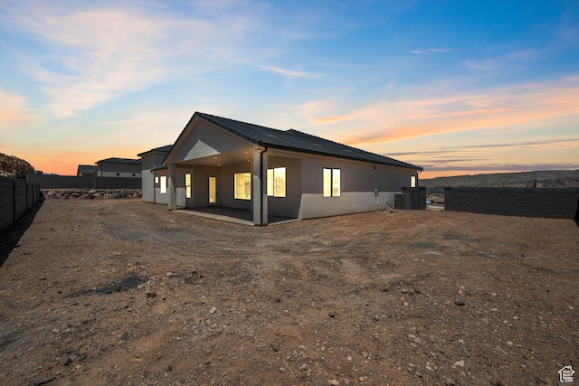 824 S 1690 W, Hurricane, UT 84737 - property exterior at dusk with a fenced backyard, stucco siding, and a patio