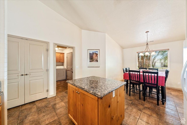 1173 W Snow Canyon Pkwy Unit 30, St George, UT 84770 - kitchen with vaulted ceiling, a chandelier, washer / clothes dryer, a center island, and pendant lighting