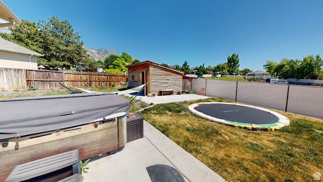 540 E 990 N, Pleasant Grove, UT 84062 - view of yard with a hot tub, a trampoline, an outdoor structure, a mountain view, and a patio