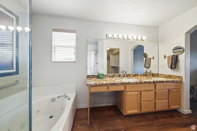 13708 S Manas Ct, Herriman, UT 84096 - bathroom featuring double vanity, a jetted tub, wood finished floors, and a shower