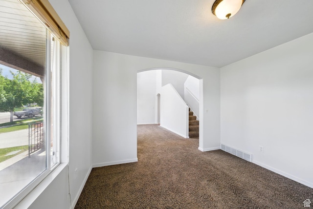 13708 S Manas Ct, Herriman, UT 84096 - empty room featuring carpet flooring, plenty of natural light, arched walkways, and baseboards