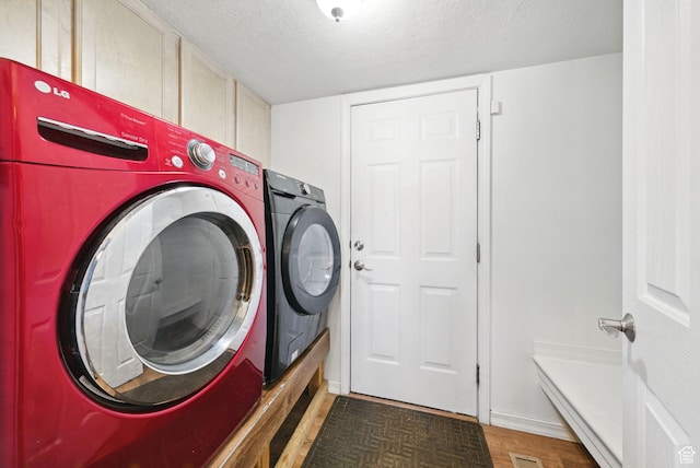 13708 S Manas Ct, Herriman, UT 84096 - washroom with washer and dryer, cabinet space, a textured ceiling, light wood-style flooring, and baseboards