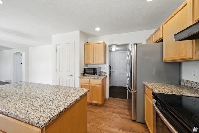 13708 S Manas Ct, Herriman, UT 84096 - kitchen with stainless steel appliances, arched walkways, recessed lighting, light wood-style floors, and light brown cabinetry