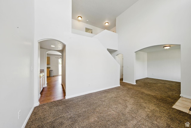13708 S Manas Ct, Herriman, UT 84096 - carpeted spare room with arched walkways, a towering ceiling, and baseboards