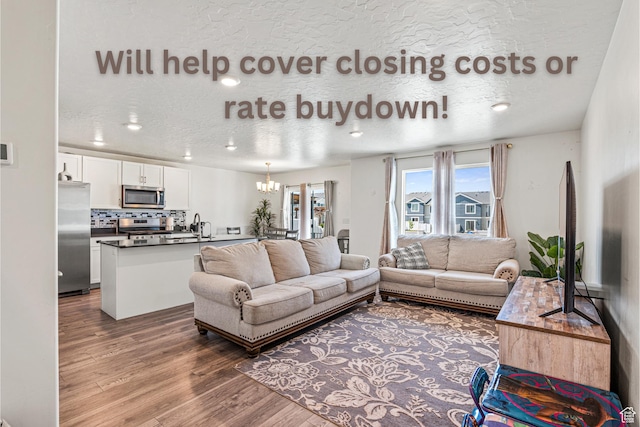 3970 W Cool Spring Ave, Lehi, UT 84043 - living room with wood finished floors, a chandelier, a textured ceiling, and recessed lighting