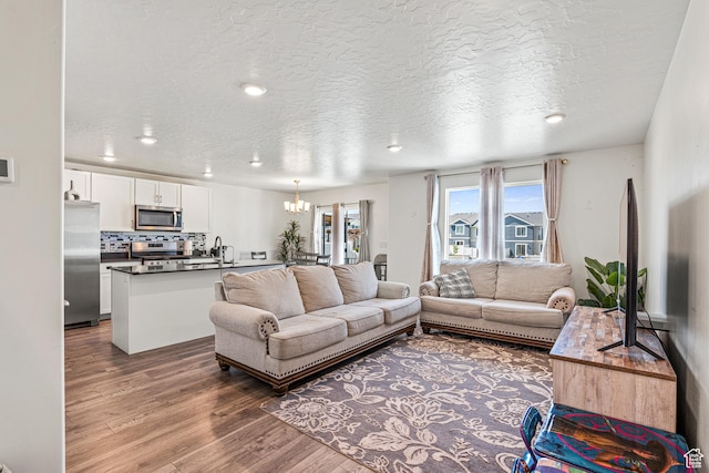 3970 W Cool Spring Ave, Lehi, UT 84043 - living area featuring wood finished floors, a chandelier, a textured ceiling, and recessed lighting