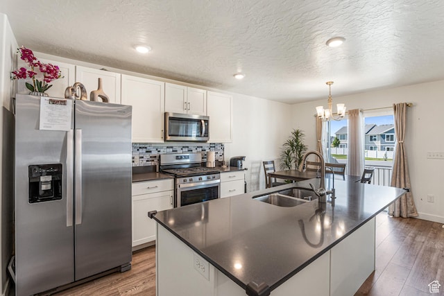 3970 W Cool Spring Ave, Lehi, UT 84043 - kitchen featuring stainless steel appliances, a sink, dark countertops, white cabinets, and a chandelier