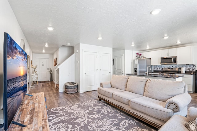 3970 W Cool Spring Ave, Lehi, UT 84043 - living room featuring light wood-style floors, baseboards, recessed lighting, and a textured ceiling