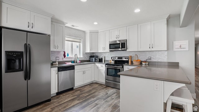 225 W 1390 N, Orem, UT 84057 - kitchen featuring stainless steel appliances, a peninsula, dark countertops, white cabinets, and backsplash