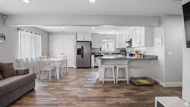 225 W 1390 N, Orem, UT 84057 - kitchen with appliances with stainless steel finishes, a peninsula, dark wood-style flooring, open floor plan, and recessed lighting
