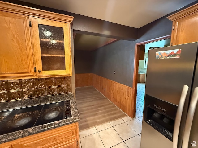 1144 W Bloomington Dr S, St George, UT 84790 - kitchen featuring stainless steel refrigerator with ice dispenser, wainscoting, light tile patterned flooring, glass insert cabinets, and dark stone counters