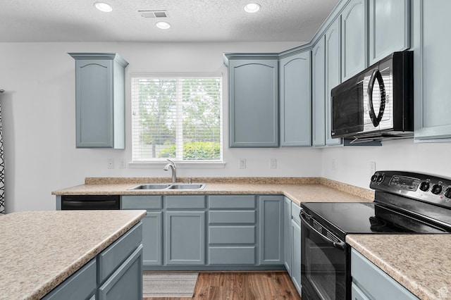 4699 W Greensand Dr S, West Jordan, UT 84084 - kitchen featuring black appliances, a sink, wood finished floors, a textured ceiling, and light countertops