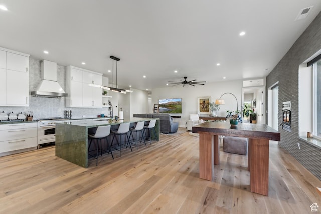 2711 S 500 E, Francis, UT 84036 - kitchen featuring custom range hood, an island with sink, white cabinetry, a breakfast bar area, and a sink