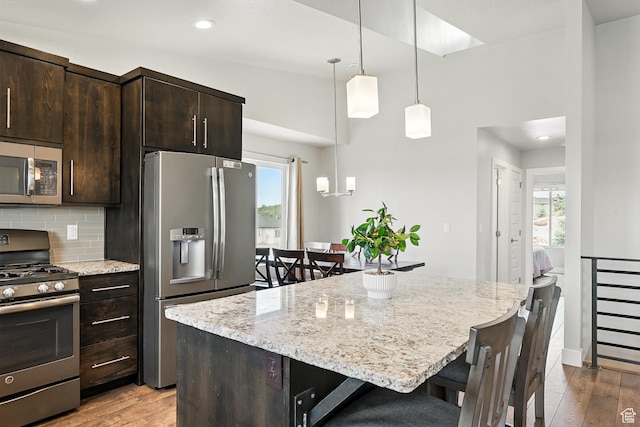 48 S Cimarron Cir, Cedar City, UT 84720 - kitchen with appliances with stainless steel finishes, a breakfast bar, wood finished floors, dark brown cabinetry, and recessed lighting