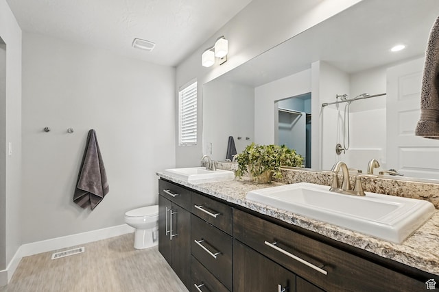 48 S Cimarron Cir, Cedar City, UT 84720 - full bathroom with toilet, double vanity, wood finished floors, baseboards, and a shower