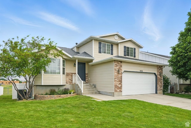 1826 N 2600 W, Lehi, UT 84043 - split level home featuring concrete driveway, a front yard, an attached garage, and brick siding